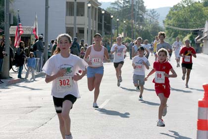 Melania Mahoney Runners in the 2.2 mile race approach the finish line in front of the Cheese Factory on Spain Street.